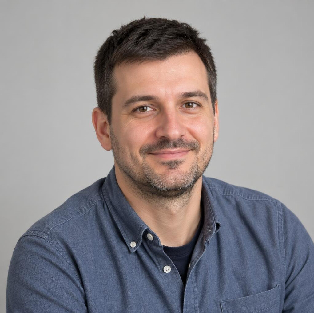 Portrait of a man with short dark hair and light stubble